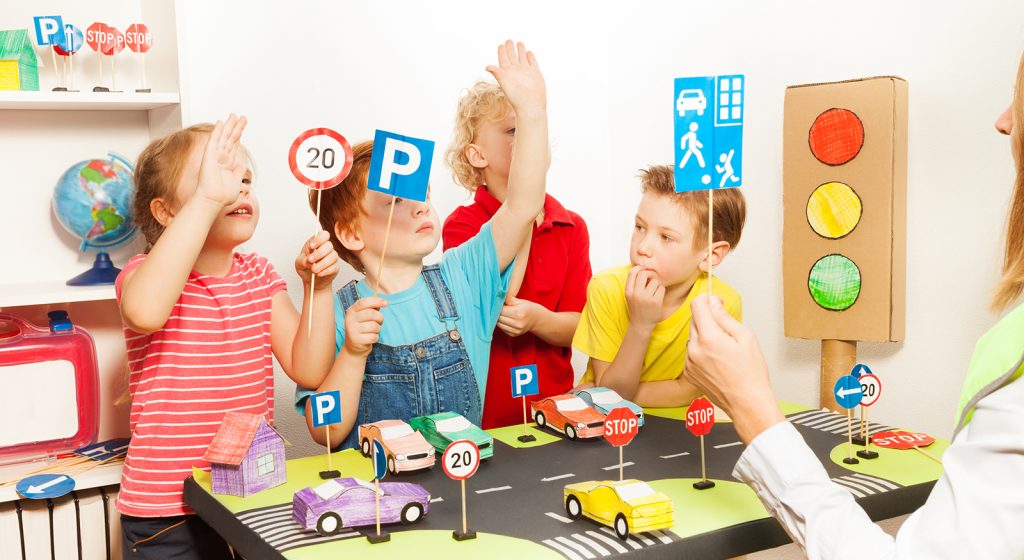 Kids raising their hands up at road safety lesson