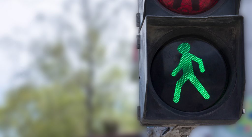 A traffic light with a green little man. Safety on the roads. Life insurance.